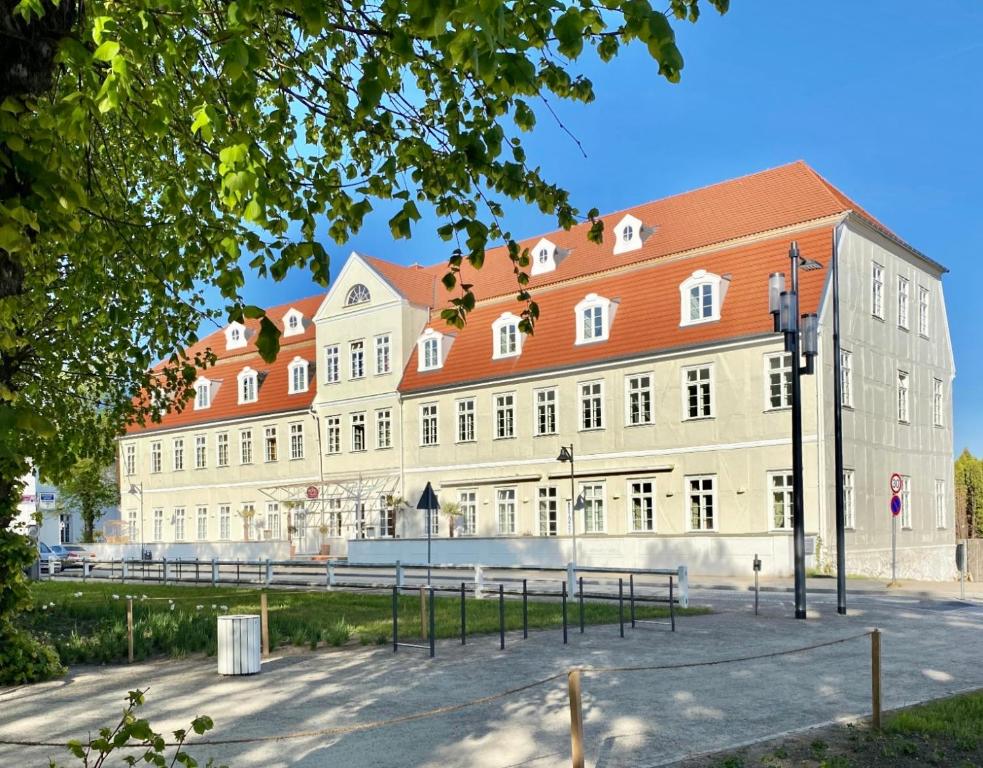 un grand bâtiment blanc avec un toit rouge dans l'établissement Hotel "Friedrich-Franz-Palais", à Bad Doberan