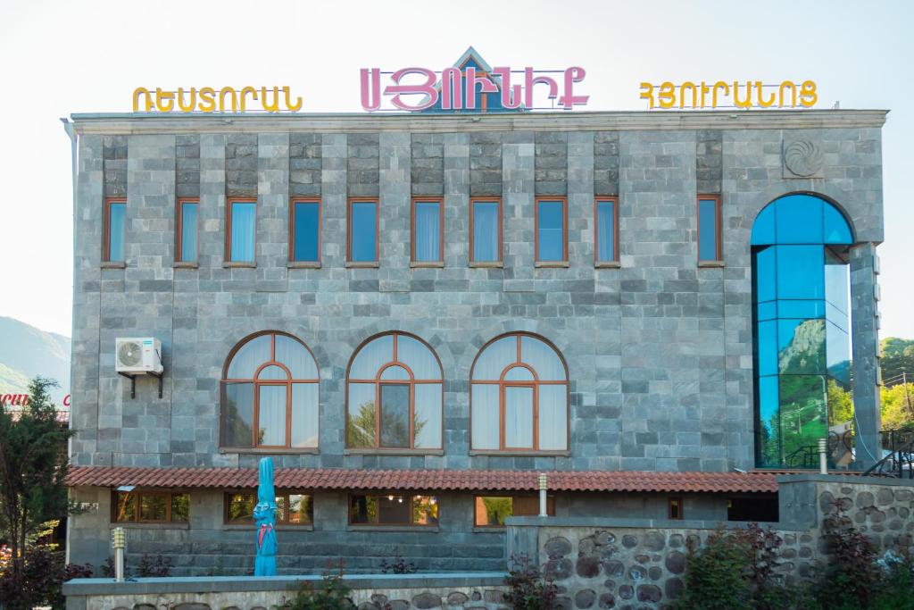 a building with a sign on top of it at Syuniq Hotel in Goris