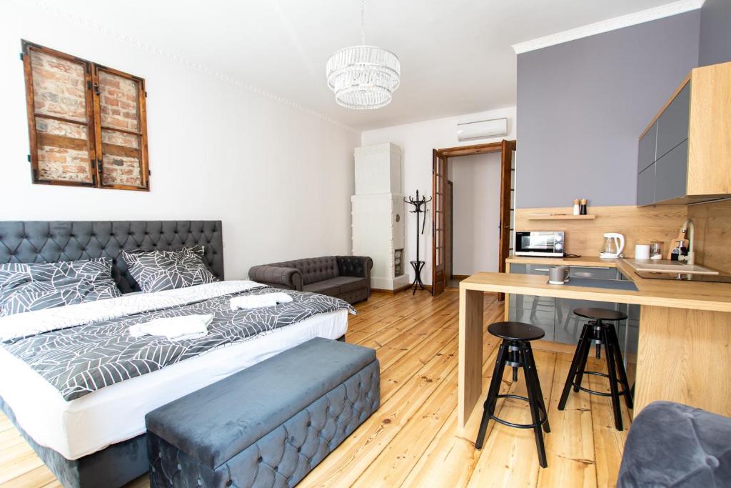 sypialnia z dużym łóżkiem i kuchnią w obiekcie Szymborska Apartamenty Mostowa 18-2 w Toruniu