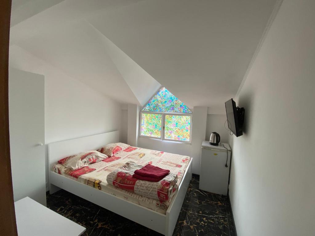 a small bedroom with a bed with a window at Lemberg Relax House in Lviv