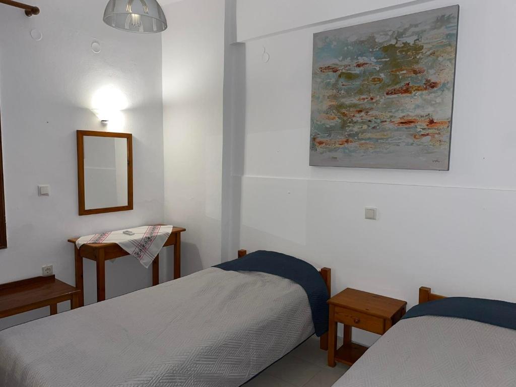 a bedroom with two beds and a painting on the wall at Livadia Studios in Ropanianá