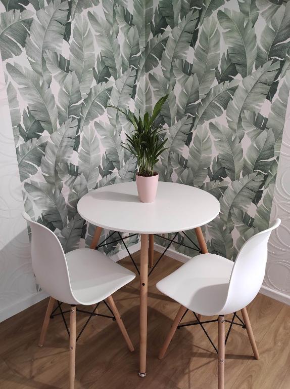 a table and two chairs and a plant on a wall at Appartement Oingt - Les Meublés des Pierres Dorées in Theizé