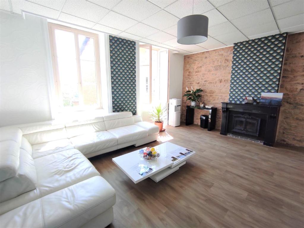 a living room with a white couch and a table at Appartement Oingt - Les Meublés des Pierres Dorées in Theizé