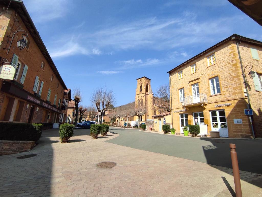 an empty street in a town with a church at Appartement Oingt - Les Meublés des Pierres Dorées in Theizé