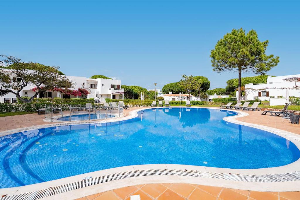 a large swimming pool with blue water at Charming Balaia Golf Village Apartment - Sleeps 6 in Albufeira