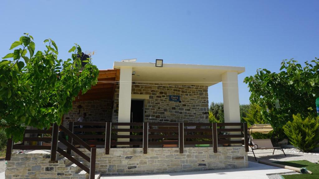 ein Gebäude mit einer Veranda mit Bäumen davor in der Unterkunft Oasis house - for relaxing holidays near the beach in Kalamaki
