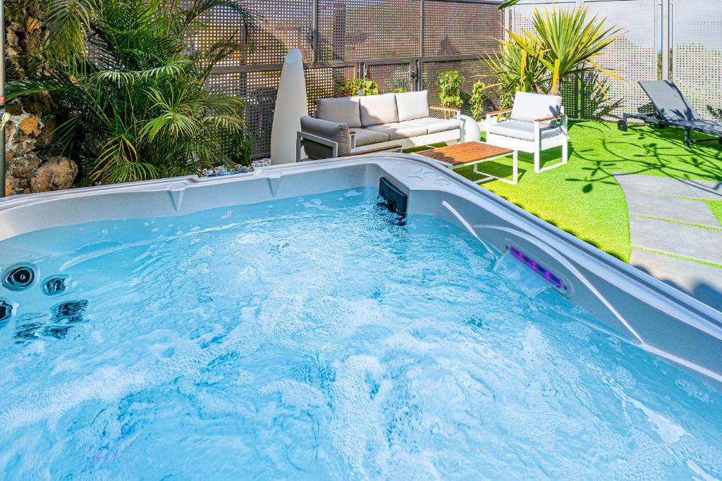 a large hot tub in a yard with a patio at Villa Loft Jacuzzi Teleworking WIFI in San Miguel de Abona
