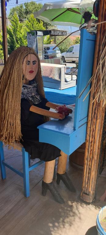 a doll sitting on a blue chair with an umbrella at Grand Yayla Hotel in Çeşme