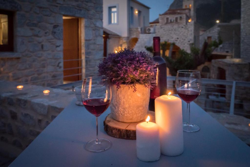 una mesa con dos copas de vino y dos velas en Kapetan Matapas 16th Cen. Tower, en Areopoli