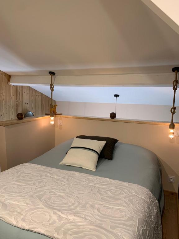 a bedroom with a bed with a light above it at La Casita in Pouilly-le-Monial