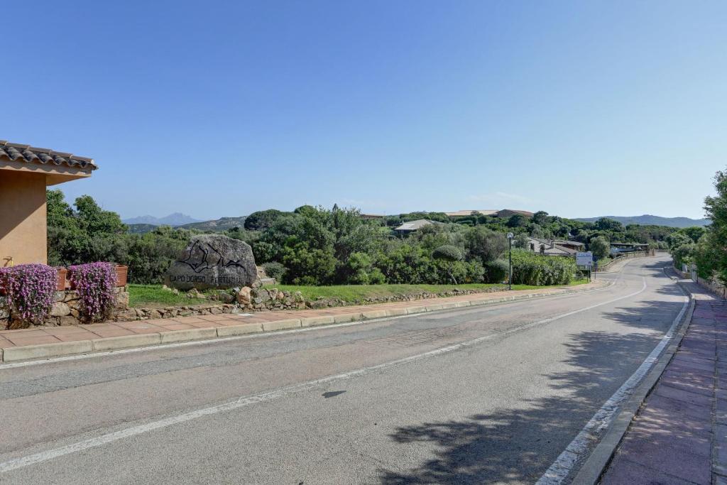 an empty road with a building and trees at VILLA MARIA - CAPO D'ORSO - HOME and MORE in Palau