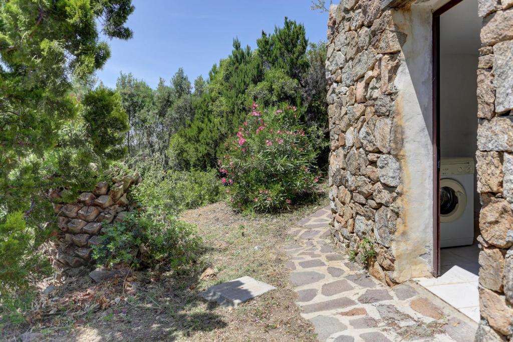 a stone house with a garden and a washing machine at VILLA MARIA - CAPO D'ORSO - HOME and MORE in Palau