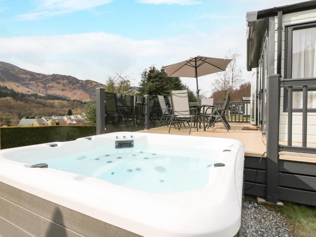 a hot tub on the deck of a house at Red Kite Lodge in Crieff