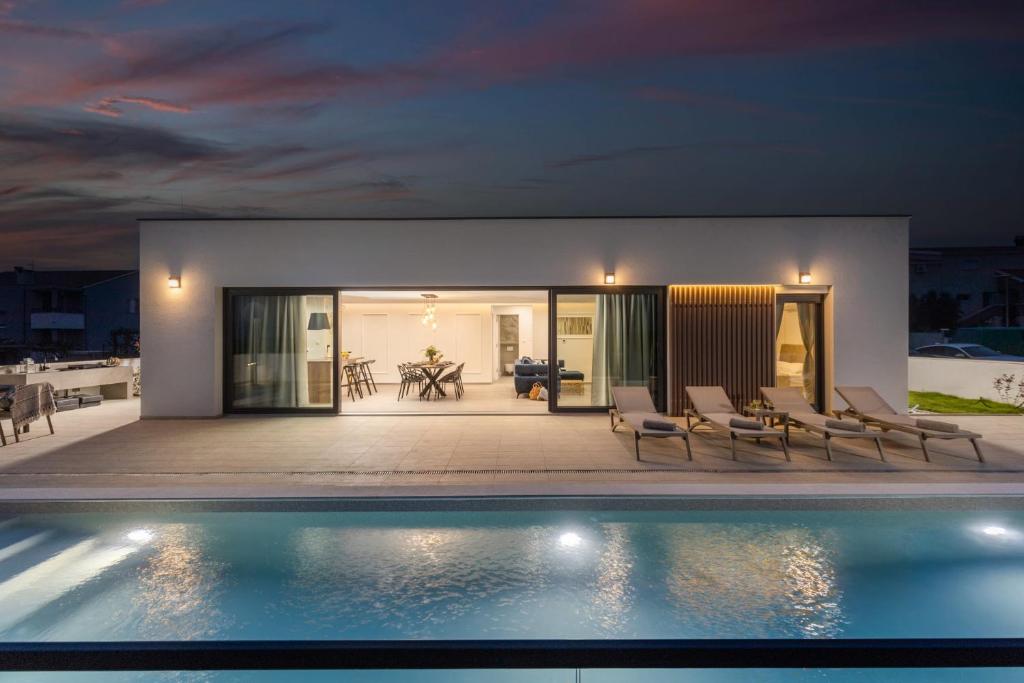 Villa con piscina por la noche en Villa Coralis With Heated Pool, en Vrsi