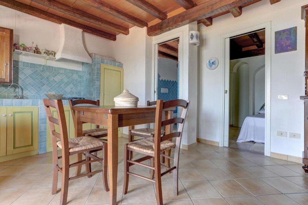 a kitchen with a wooden table and chairs at VILLA MARIA - CAPO D'ORSO - HOME and MORE in Palau