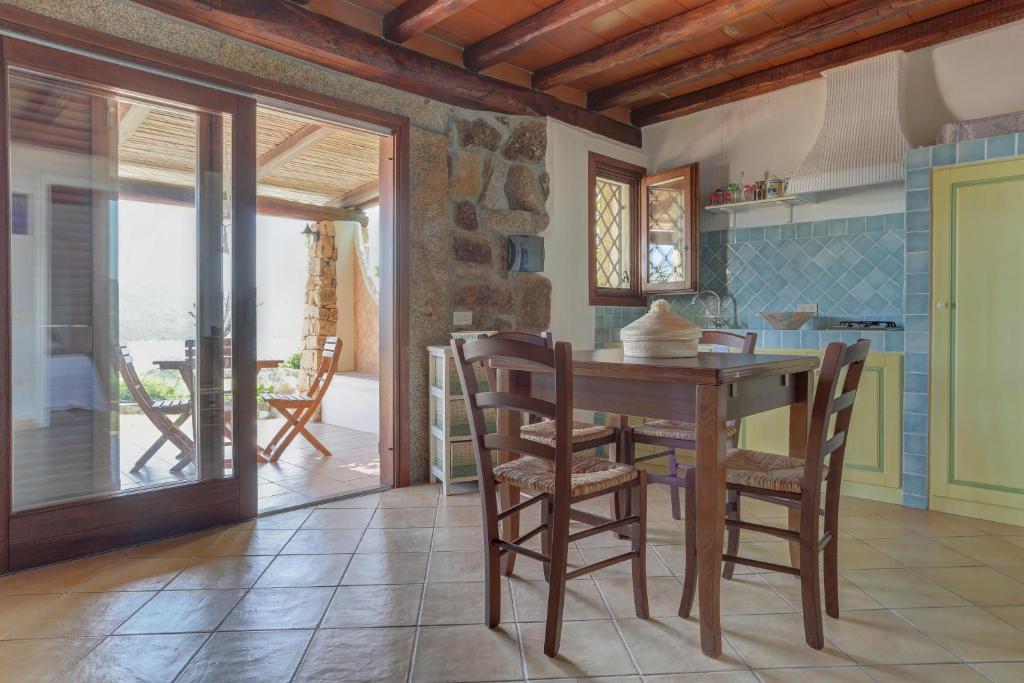 a kitchen with a wooden table and chairs in a room at VILLA MARIA - CAPO D'ORSO - HOME and MORE in Palau