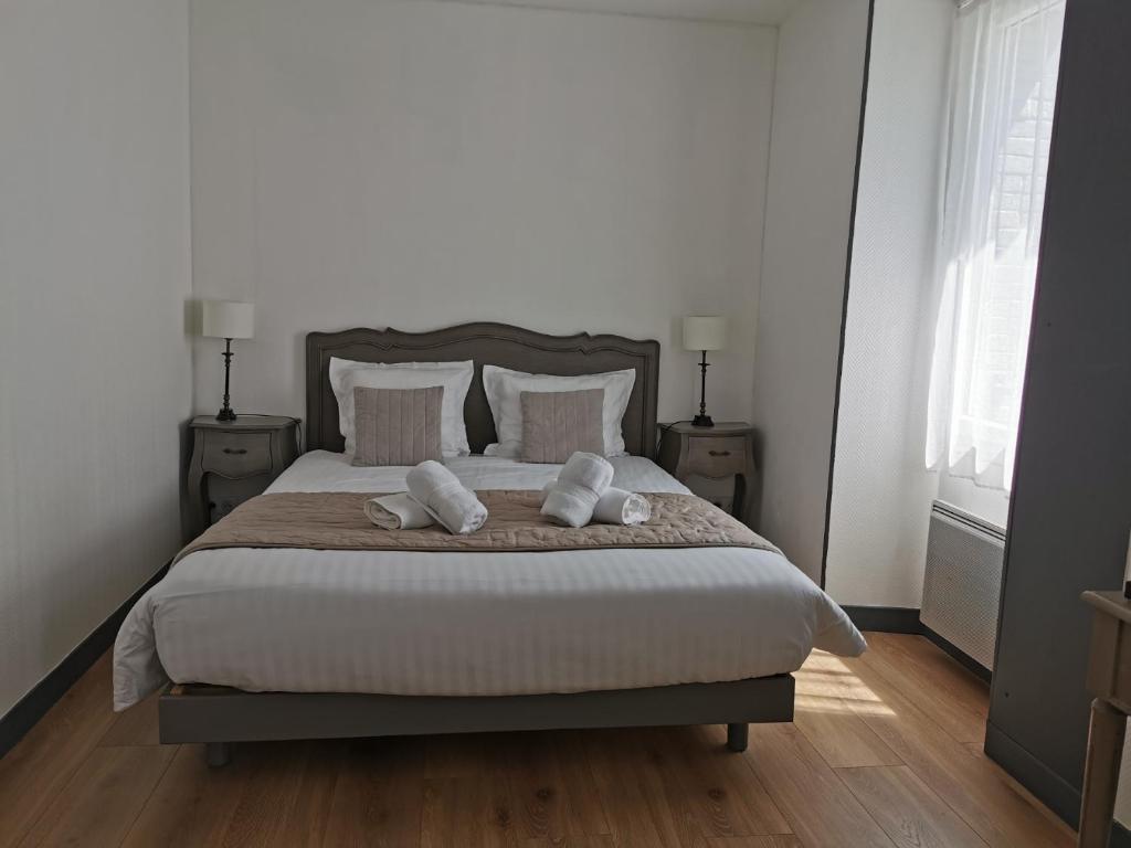 a bedroom with a large bed with two pillows at L'estacade in Le Croisic