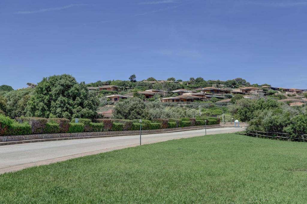an empty road in a park with buildings in the background at VILLA MARIA - CAPO D'ORSO - HOME and MORE in Palau
