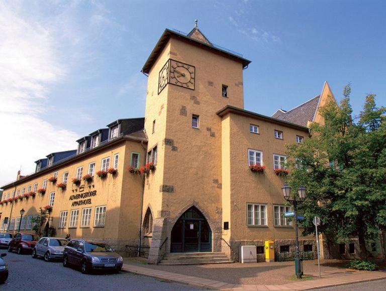 a building with a clock tower on the side of it at Altwernigeröder Apparthotel in Wernigerode