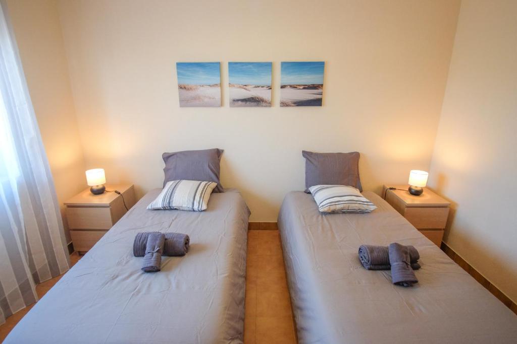2 camas individuales en una habitación con 2 lámparas en Casa Madeira, en Burgau
