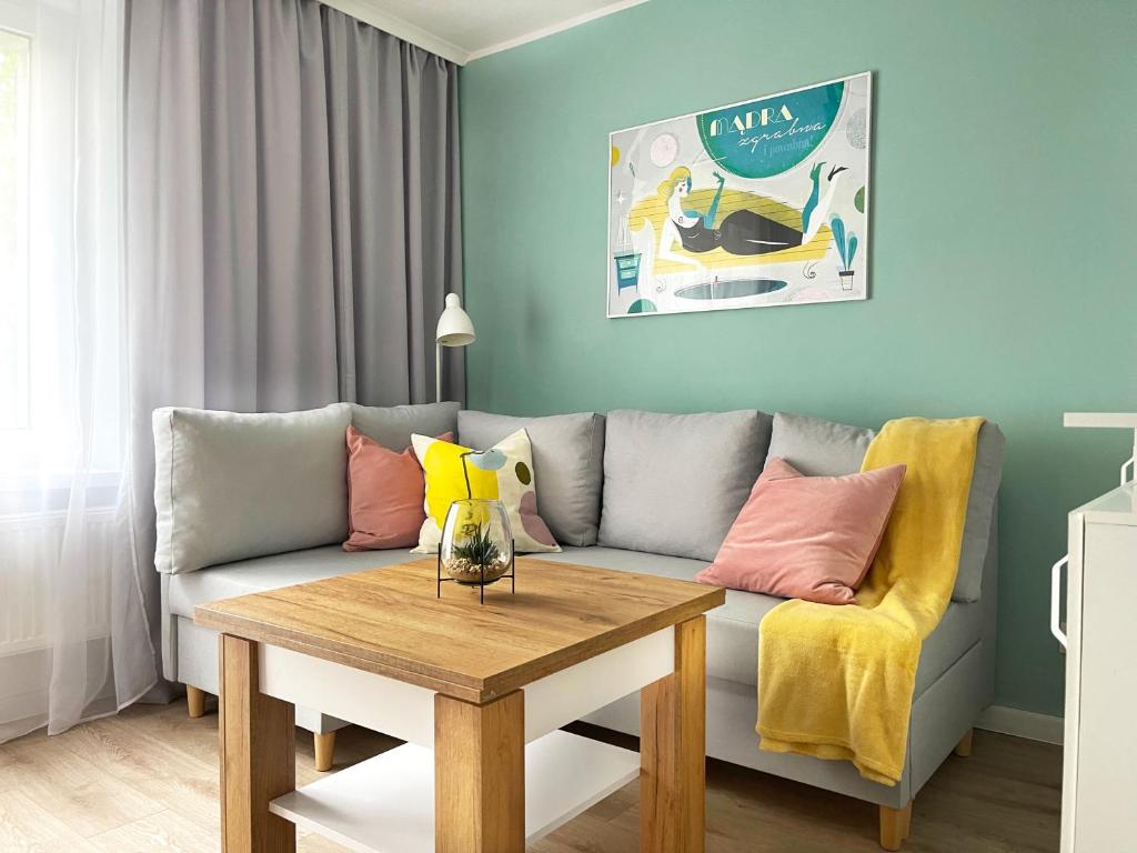 a living room with a couch and a table at Pastelowe Studio - Comfy Apartments in Gdańsk