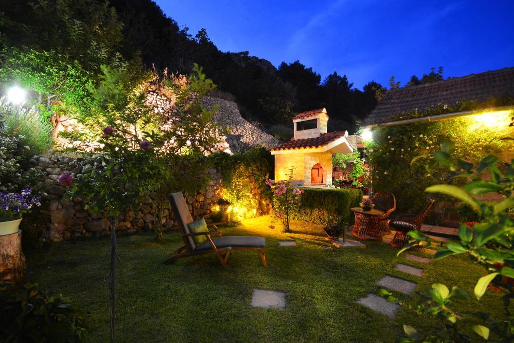 - un jardin la nuit avec une maison et des lumières dans l'établissement Artsy Apartment, à Klis