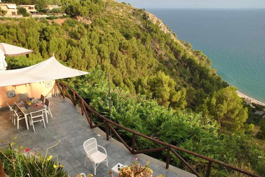 un patio con mesa y sillas junto al océano en VILLA ROMANTIC COVE vista mozzafiato sul mare, en Latina