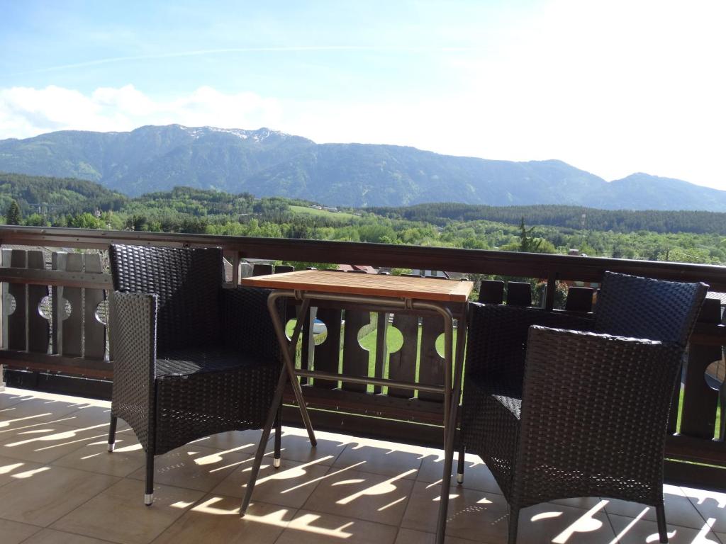 a table and chairs on a balcony with mountains at Haus Frans Josef in Seeboden