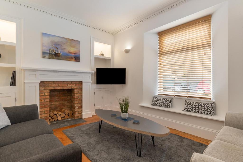 a living room with a couch and a fireplace at Falcon House in Pembroke Dock