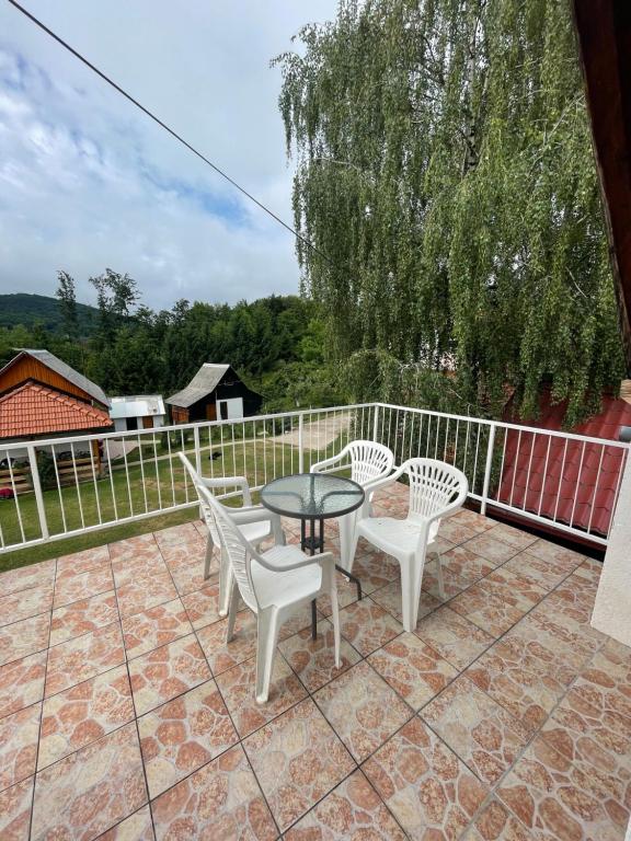 un patio con 3 sillas y una mesa en un patio en Apartment Plavo oko, en Smoljanac