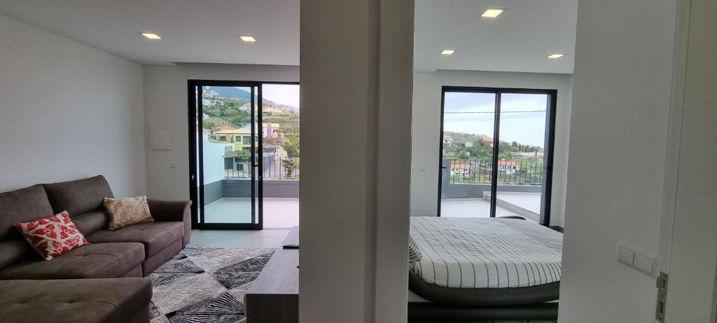 una sala de estar con un sofá y una cama en Villa Castanho I, en Calheta