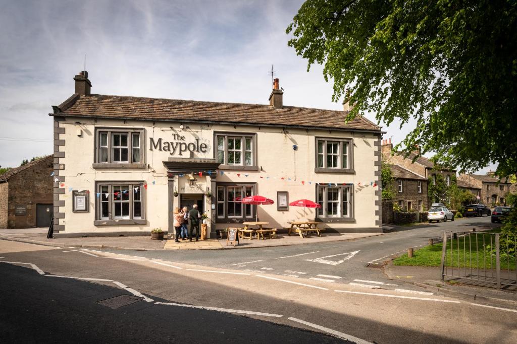 a large white building on the corner of a street at Maypole Inn in Settle