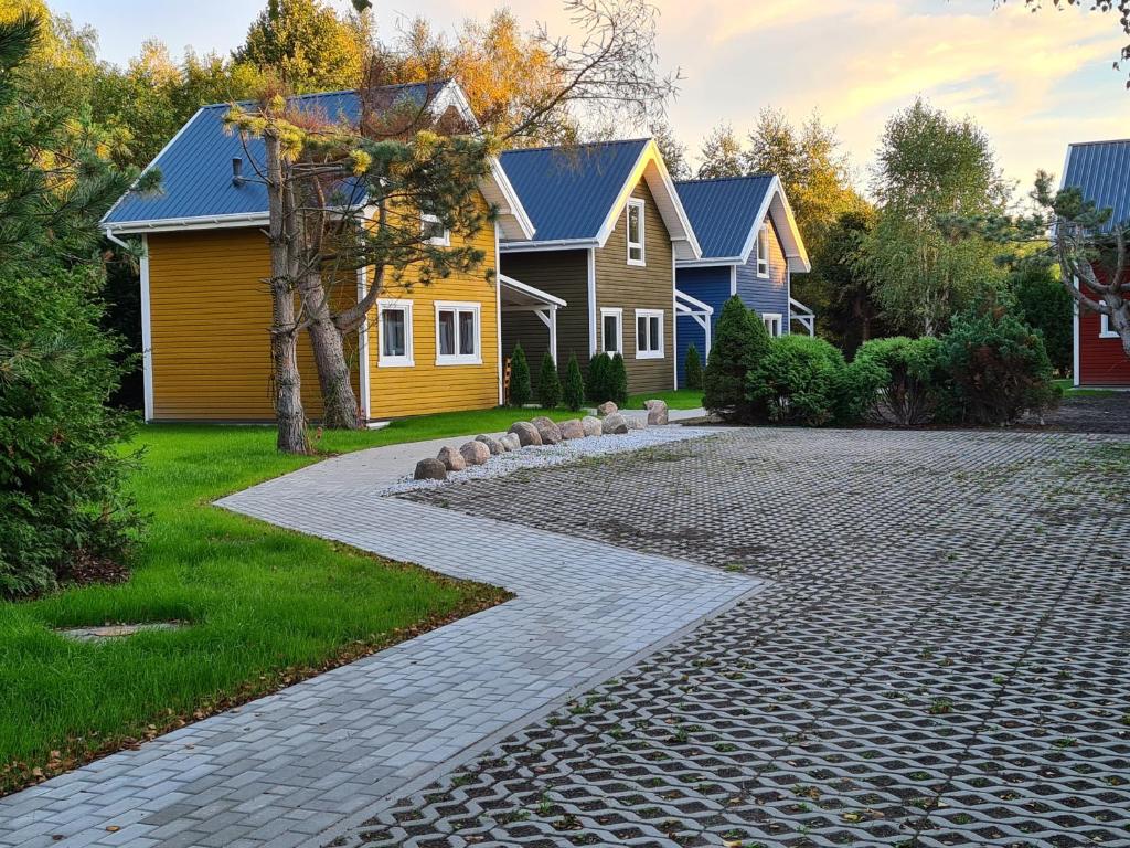 a cobblestone driveway in front of a house at FOLGI - Domki Jeżowa in Kopalino