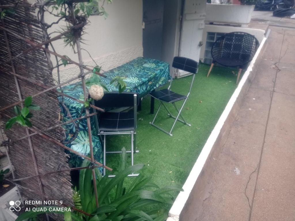 a patio with a table and chairs on grass at Charming and Modern Cave in the Heart of the Port in Nice