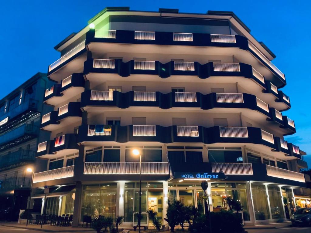 a tall building with a lit up facade at night at Hotel Bellevue in Caorle