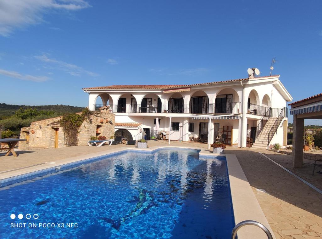 a large house with a swimming pool in front of it at Finca Tierra Roja in Cálig