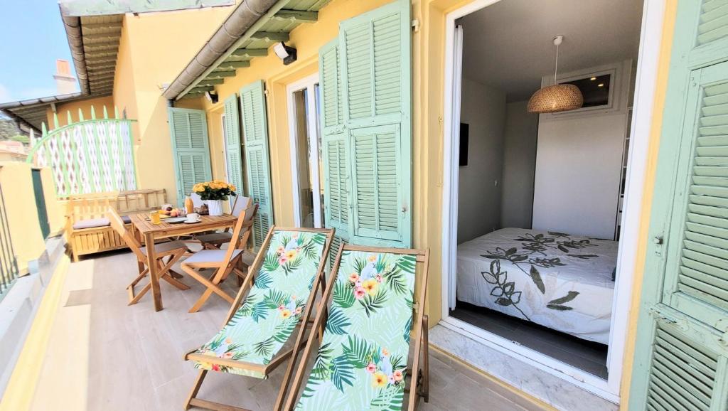 - un balcon avec une table, des chaises et un lit dans l'établissement Ze Perfect Place - Opera Nice - Appartement 2 Chb - AC - Terrasse, à Nice