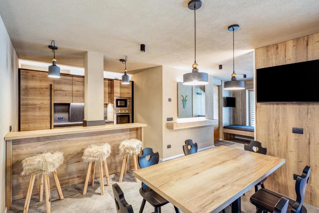 - une salle à manger avec une table et des chaises en bois dans l'établissement Appartamento Nido, à Livigno