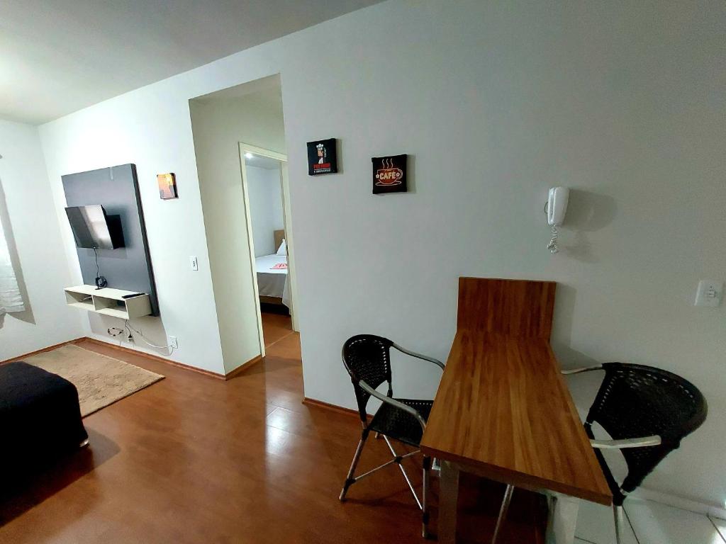 a living room with a wooden table and chairs at Apartamento próximo ao Autódromo. in Londrina