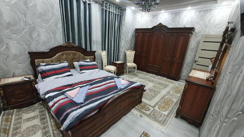 ein Schlafzimmer mit einem Bett mit einem Kopfteil aus Holz in der Unterkunft Fayzli GuestHouse in Taschkent