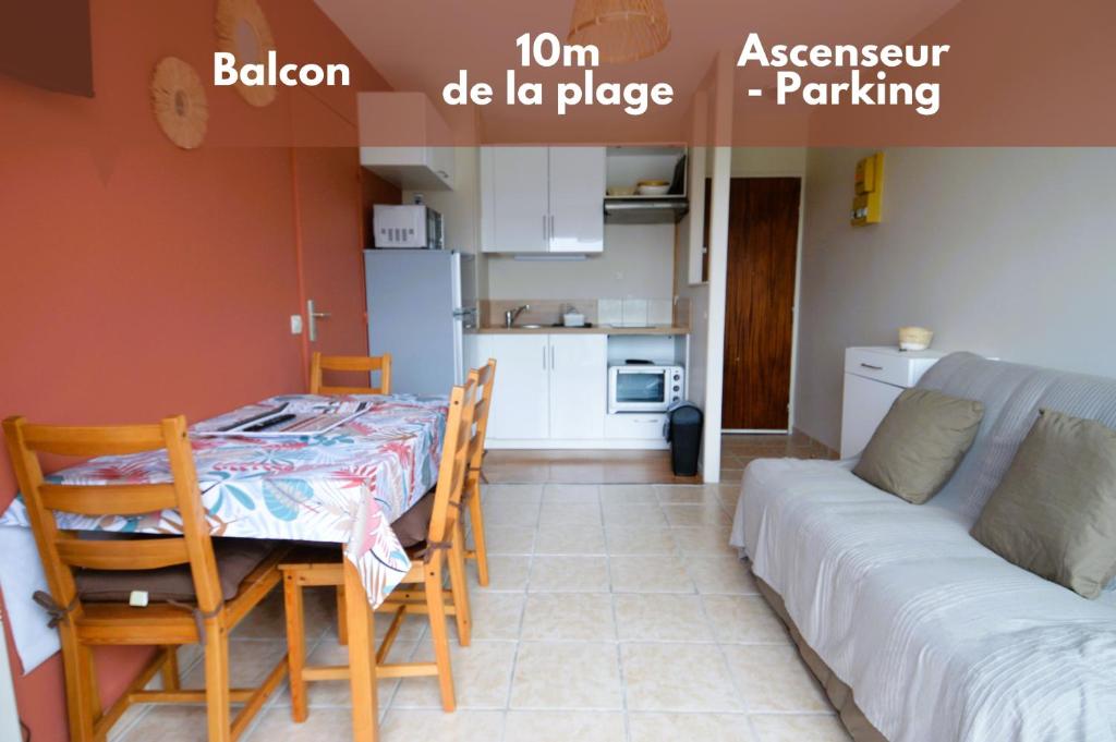 cocina y sala de estar con mesa y sofá. en Appartement au pied de la plage - Balcon - Parking, en Courseulles-sur-Mer