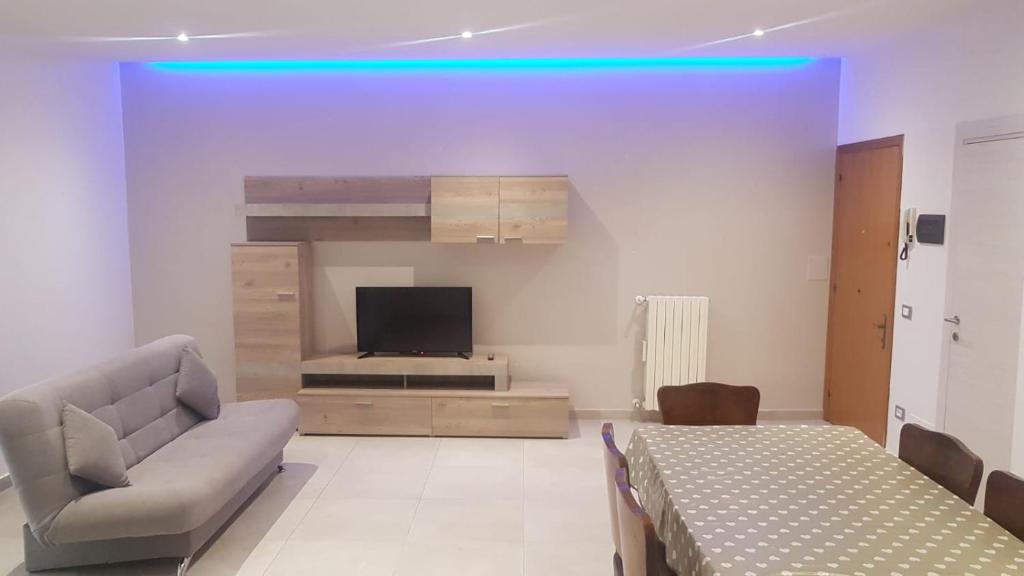 uma sala de estar com um sofá e uma televisão em Appartamento Fronte Mare em Falconara Marittima