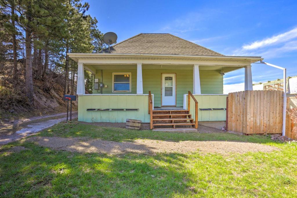 una pequeña casa amarilla con una valla de madera en Classic Mountain Home, Half Mi to Main Street en Lead