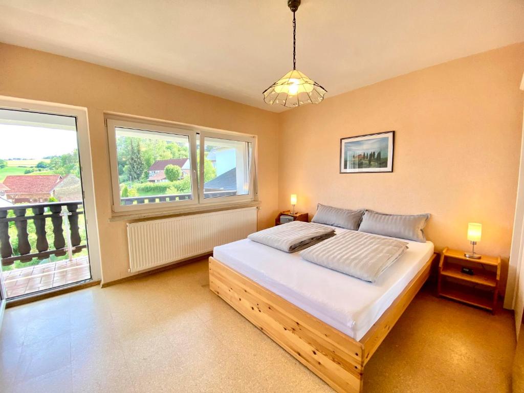 a bedroom with a bed and two windows at Alraftsblick in Waldeck