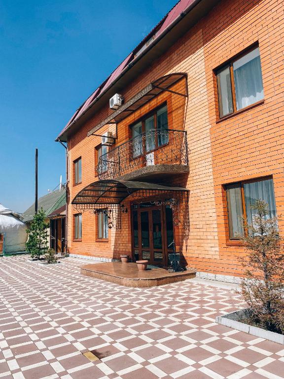 a brick building with a balcony and a patio at AL BARAKA in Borovoye