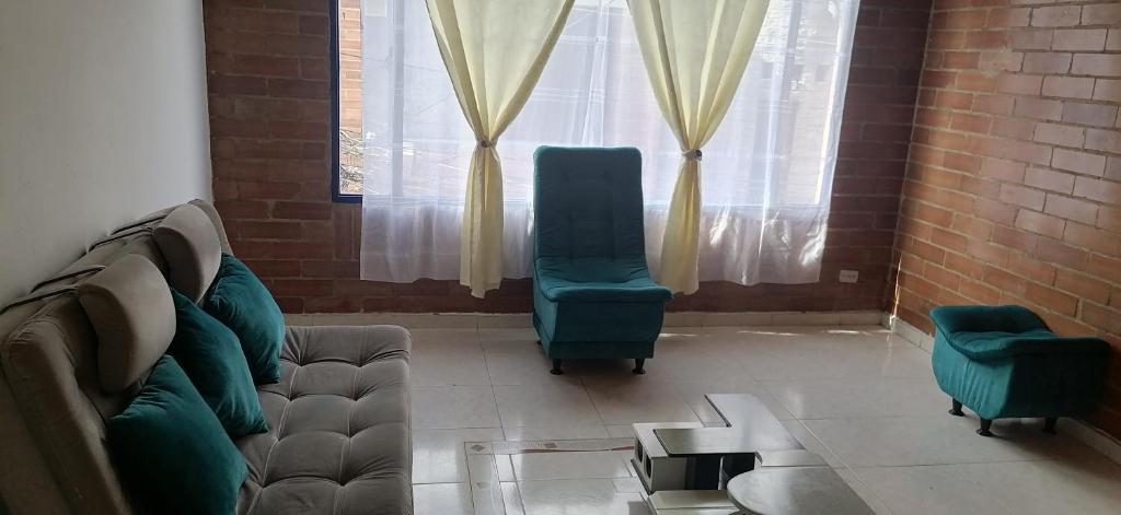 uma sala de estar com um sofá e duas cadeiras em Apartamento amplio al norte de la ciudad em Bogotá