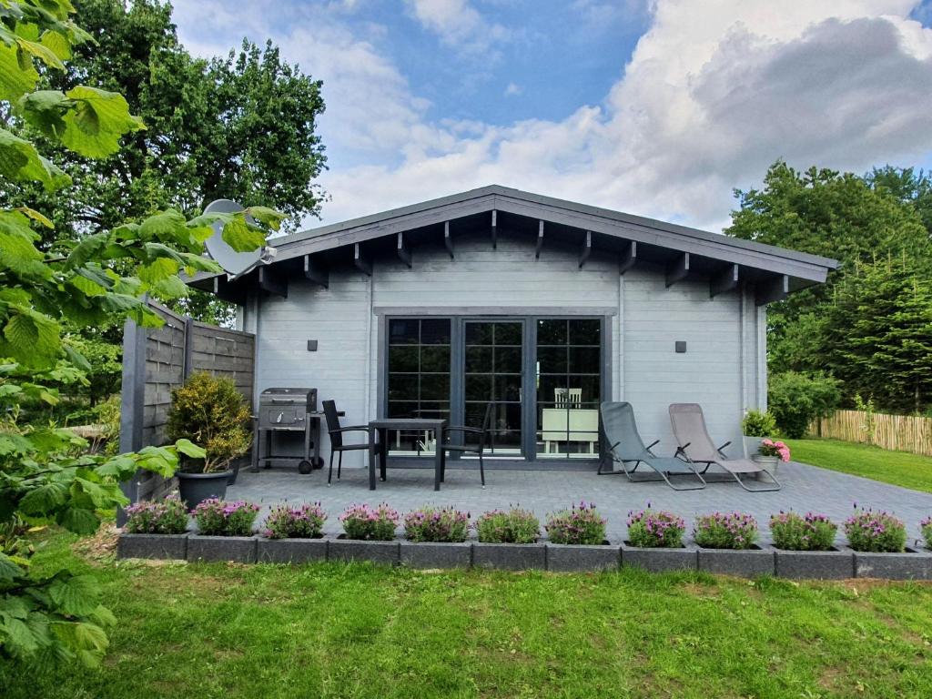 a white shed with a table and chairs in a yard at Idyllisches-Blockbohlenhaus-mit-eigenem-Garten-und-Sauna-zum-Wohlfuehlen in Martensrade