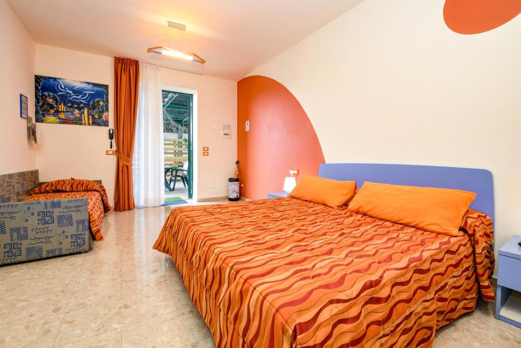 sypialnia z łóżkiem z pomarańczową narzutą w obiekcie La Forgia Apartments w mieście Peschiera del Garda