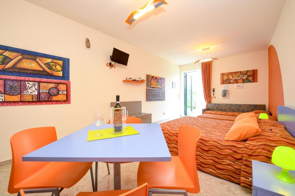 sypialnia z łóżkiem, stołem i krzesłami w obiekcie La Forgia Apartments w mieście Peschiera del Garda