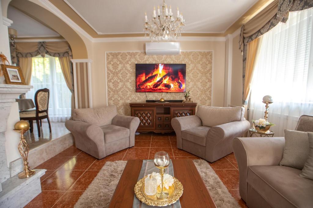a living room with a couch and chairs and a fireplace at Bükki Villa in Bükkszék